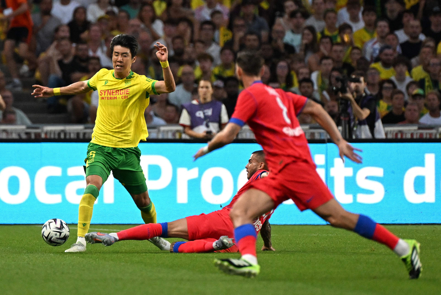 Nantes' South Korean midfielder Kwon Hyeok-kyu, left, is tackled by Paris Saint-Germain's French defender Lucas Hernandez, center, during the French L1 football match between FC Nantes and Paris Saint-Germain (PSG) at the Stade de la Beaujoire - Louis Fonteneau in Nantes, western France, on Aug. 17. [AFP/YONHAP]