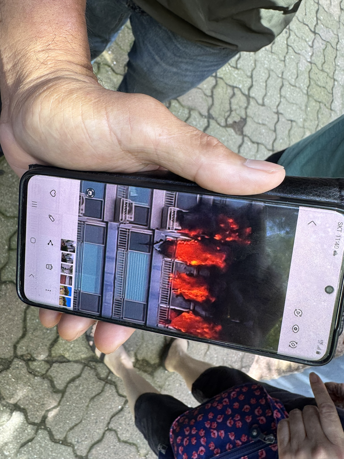 A resident of the apartment complex in Changjeon-dong, western Seoul, where a fire started on the 14th floor on the morning of Aug. 17, shows a picture of the blaze to the reporter later on the day. [IM SOUNG-BIN]