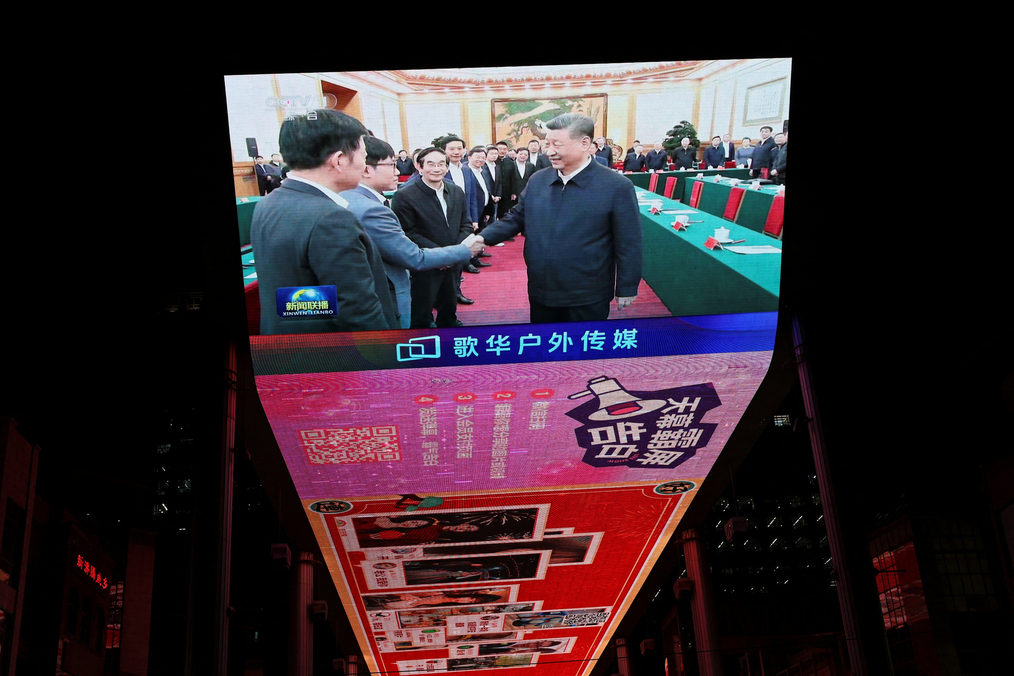 A giant screen shows Chinese President Xi Jinping shaking hands with DeepSeek founder Liang Wenfeng during a symposium on private enterprises at a shopping complex in Beijing on Feb. 17. [REUTERS/YONHAP]