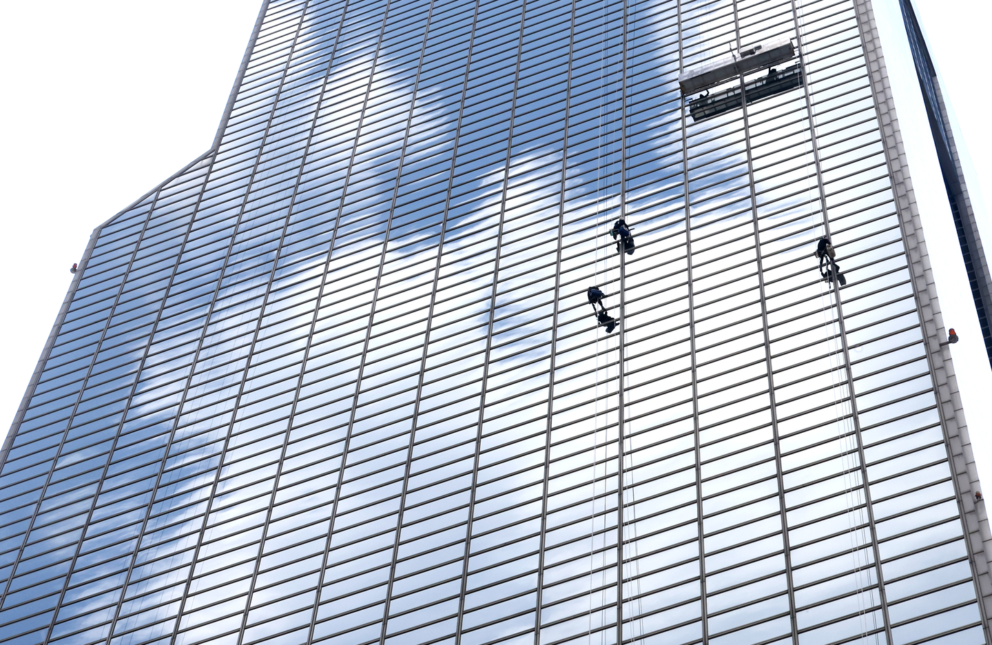  Workers clean the glass windows of a building reflecting the clouds and the blue sky in Gangnam District, southern Seoul, on Aug. 18. [YONHAP] 