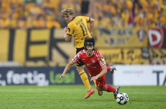 Dresden's Dominik Kother, rear, and Mainz' Lee Jae-sung, front, challenge for the ball during the German soccer cup first round match between Dynamo Dresden and FSV Mainz 05 in Dresden, Germany, Aug. 18. [AP/YONHAP]