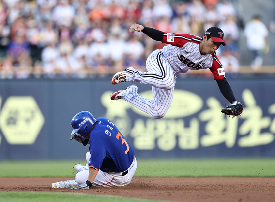 An Chi-hong of the Hanwha Eagles, left, slides into second base under LG Twins shortstop Oh Ji-hwan during the clubs' Korea Baseball Organization regular-season game at Jamsil Baseball Stadium in Seoul on Aug. 10. [YONHAP] 