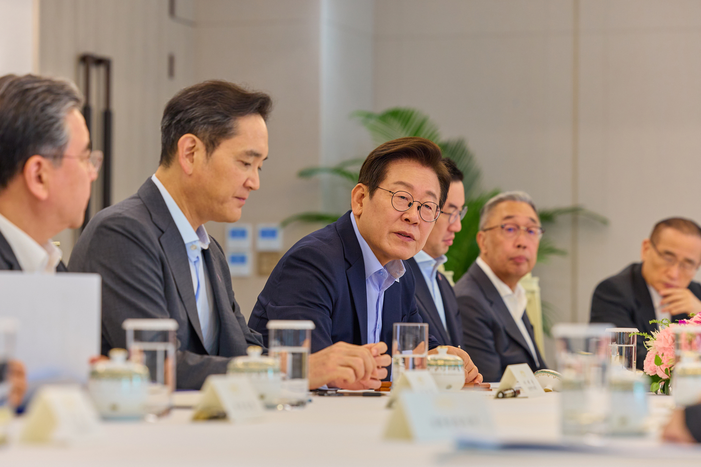 President Lee Jae Myung, third from left, speaks in a meeting with businesspeople accompanying him on his U.S. visit including Samsung Electronics Executive Chairman Lee Jae-yong, second from left, and LG Group Chairman Koo Kwang-mo, third from right, at the Yongsan presidential office in central Seoul on Aug. 19. [PRESIDENTIAL OFFICE]