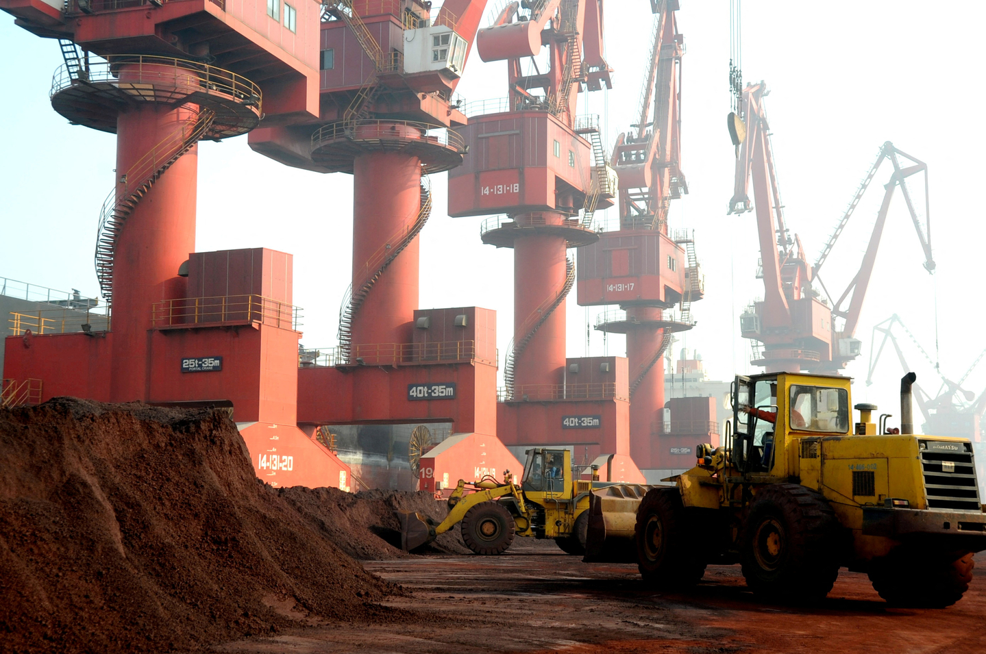 Workers transport soil containing rare earth elements for export at a port in Lianyungang, Jiangsu province, China October 31, 2010. [REUTERS]