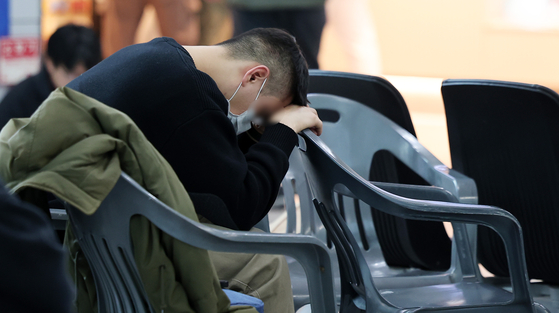 A grieving family member bows his head in sorrow at the departure hall of Muan International Airport in South Jeolla on Dec. 30, the day after a Jeju Air passenger jet crashed. [NEWS1] 