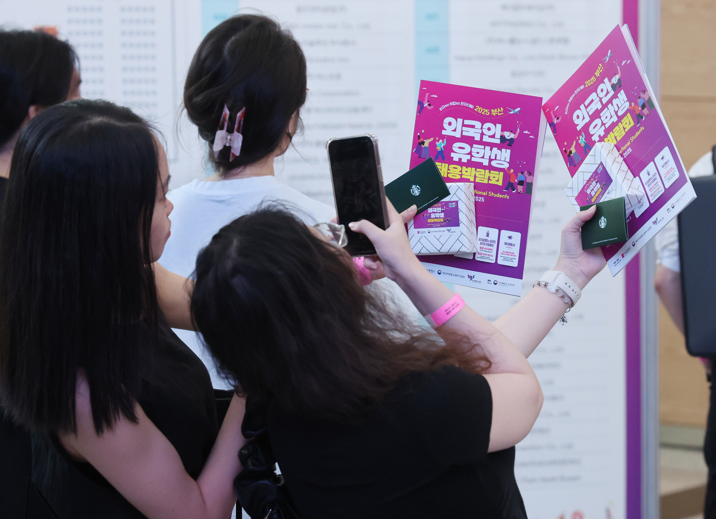 International students take photos of pamphlets at the Job Fair for International Students in Busan on Aug. 19. [YONHAP]