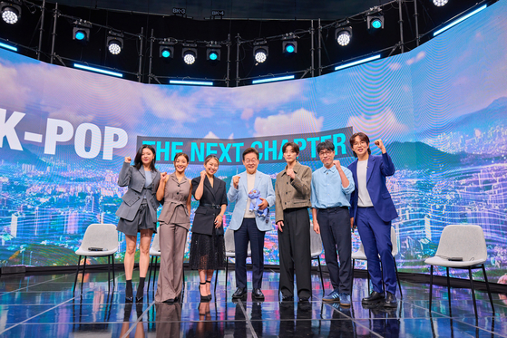President Lee Jae Myung, center, poses for a photo after speaking on a panel discussing the future vision of the K-pop industry in Seocho-dong, southern Seoul, in a prerecorded broadcast aired by Arirang TV on Aug. 20. Other panelists included Maggie Kang, writer and director of "KPop Demon Hunters," members Jihyo and Jeongyeon of K-pop girl group Twice and music producer R.Tee. [PRESIDENTIAL OFFICE]