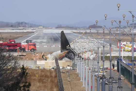 The wreckage of a Boeing 737-800 plane operated by Jeju Air lies at Muan International Airport in Muan, South Jeolla on Dec. 31. [AP/YONHAP] 