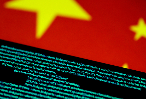Computer code is seen on a screen above a Chinese flag in this July 12, 2017 illustration photo. [REUTERS/YONHAP]