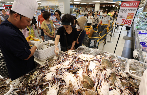 Shoppers browse blue crabs at a large supermarket in Seoul on Aug. 21. [YONHAP]