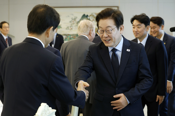 President Lee Jae Myung greets Unification Minister Chung Dong-young during a luncheon meeting with senior advisers of the Democratic Party at the presidential office in Yongsan, central Seoul, on Aug. 21. [JOINT PRESS CORPS]