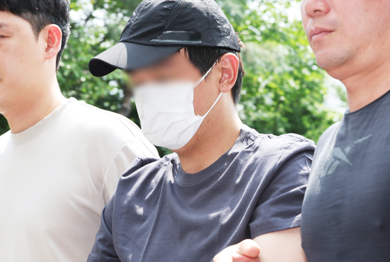 A man accused of killing a Chinese woman at an officetel parking lot in Yongin, Gyeonggi, on Aug. 21 is brought to the Yongin Seobu Police Station on Aug. 22 after being arrested at Hongcheon County, Gangwon, the same day. [YONHAP] 