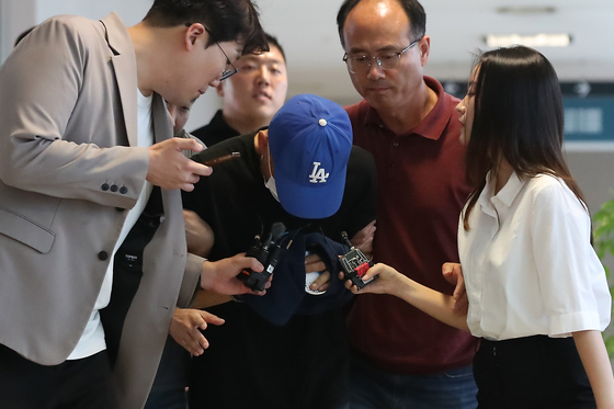 A suspect accused of fatally stabbing a woman in her 50s after stalking her and breaking into her apartment in Dalseo District, Daegu, enters the Daegu District Court’s western branch on June 16 for a pretrial detention hearing. [NEWS1]