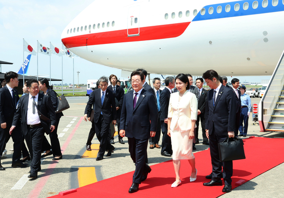 President Lee Jae Myung, left, and first lady Kim Hea Kyung arrive at Haneda Airport on Aug. 23 for a two-day visit to Japan before heading to the United States. [JOINT PRESS CORPS]