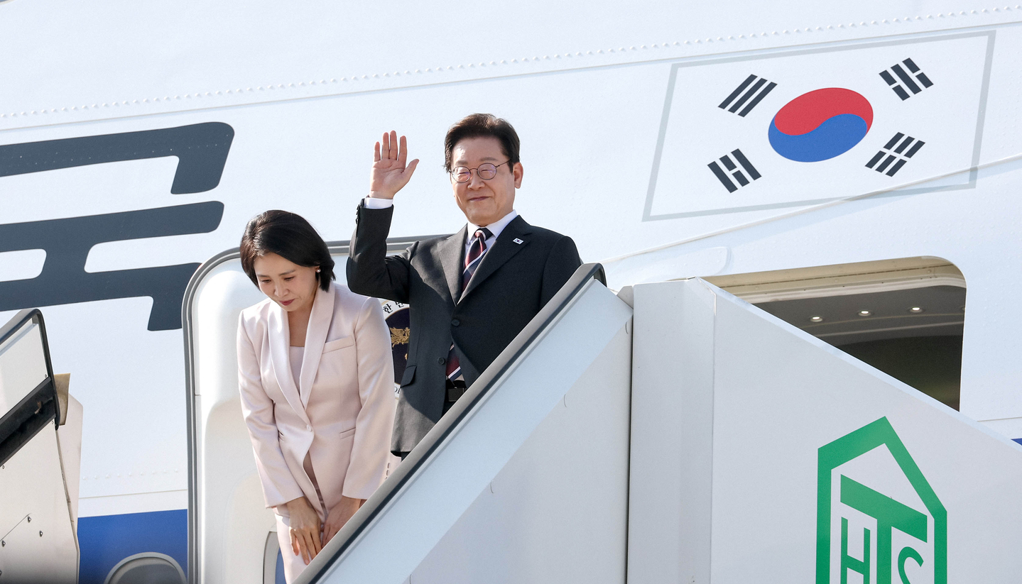 President Lee Jae Myung, right, and First Lady Kim Hea Kyung wave as they board Air Force One at Haneda Airport in Tokyo on Aug. 24. [JOINT PRESS CORPS] 