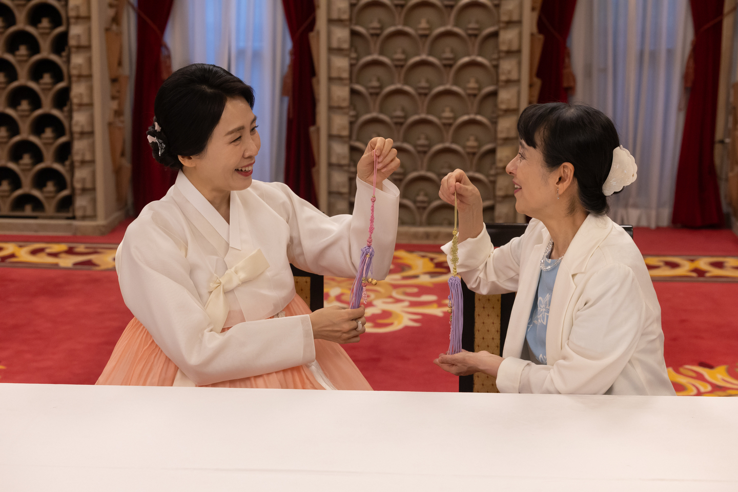 First lady Kim Hea Kyung, left, and Japanese first lady Yoshiko Ishiba exchange norigae, or traditional knots, created during a friendship event at the prime minister’s official residence in Tokyo on Aug. 23. [JOINT PRESS CORPS]