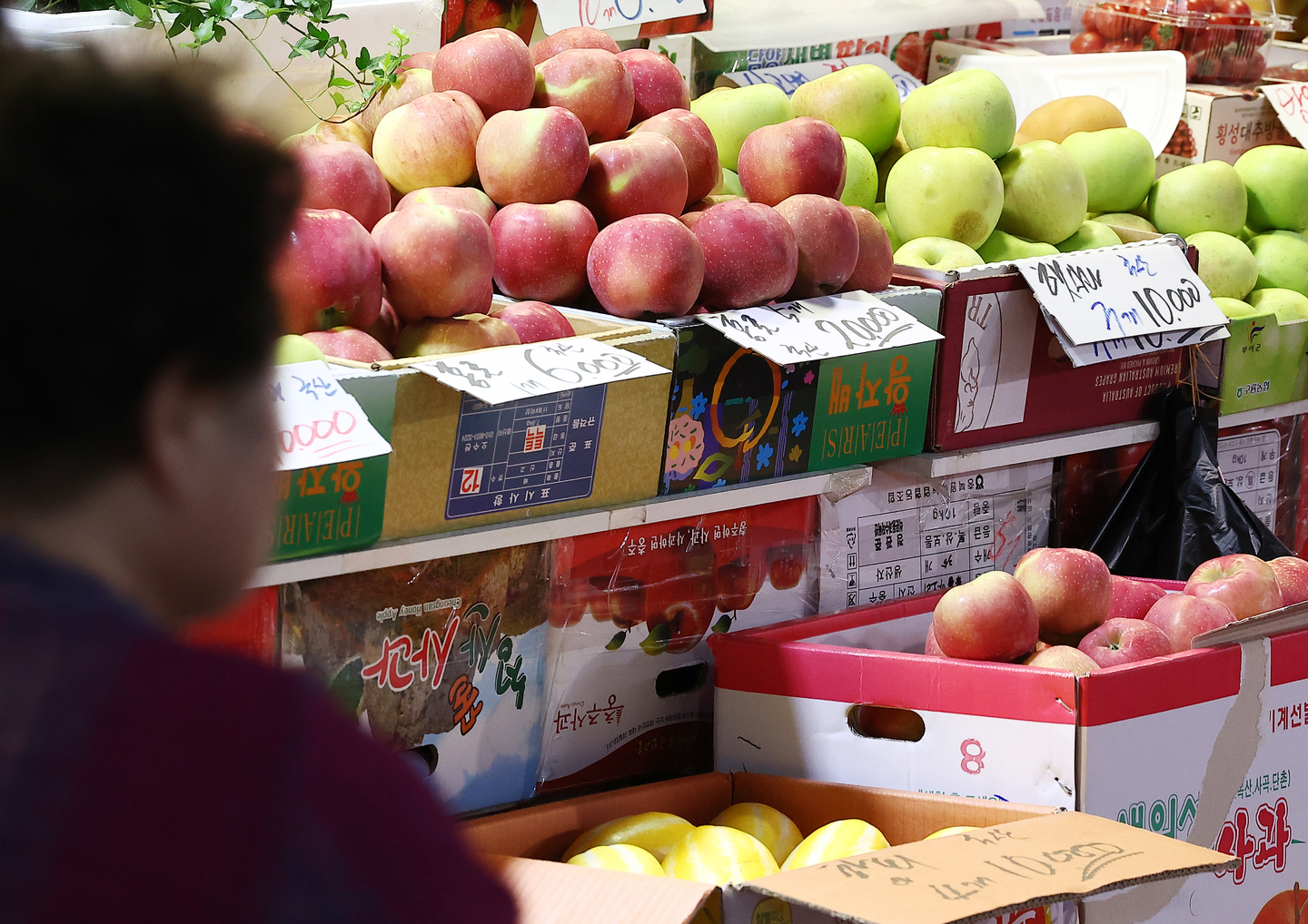 A shopper looks at fruit displayed at a traditional market in Seoul on Aug. 21. [YONHAP] 