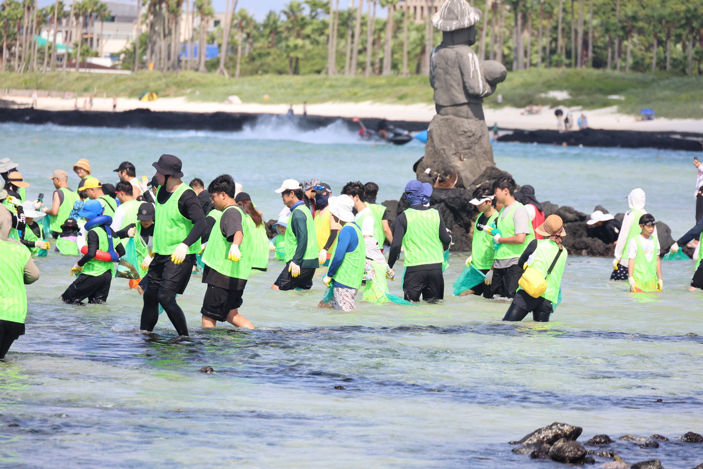 Participants catch fish with their bare hands inside a stone fish trap during the Geumnung Wondam Festival at Geumnung Beach in Hallim-eup, Jeju, on Aug. 24. [YONHAP]