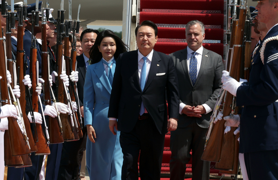 President Yoon Suk Yeol, right, and first lady Kim Keon Hee arrive at Andrews Air Force Base near Washington on the afternoon of April 24, 2023 for a state visit to the United States and walk past an honor guard. [JOONGANG ILBO]