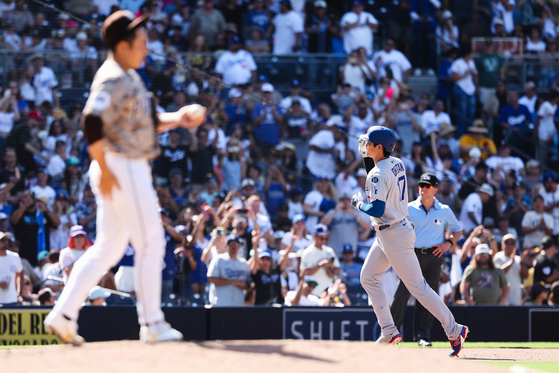 Los Angeles Dodgers' Shohei Ohtani, right, tips his cap as he runs the bases after hitting a solo homer off the San Diego Padres' Yuki Matsui, foreground, in the ninth inning of a baseball game against the San Diego Padres at Petco Park in San Diego on Aug. 24. [AP/YONHAP]