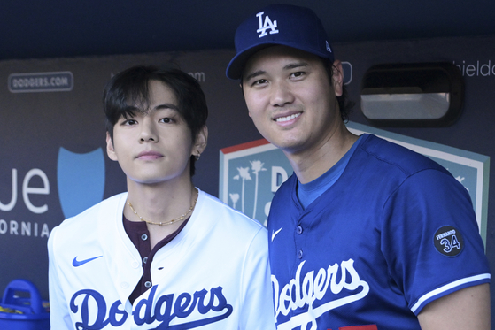 V of boy band BTS, left, poses for a photo with Los Angeles Dodgers' designated hitter Shohei Ohtani before a baseball game against the Cincinnati Reds on Aug. 25 in Los Angeles. [AP/YONHAP]