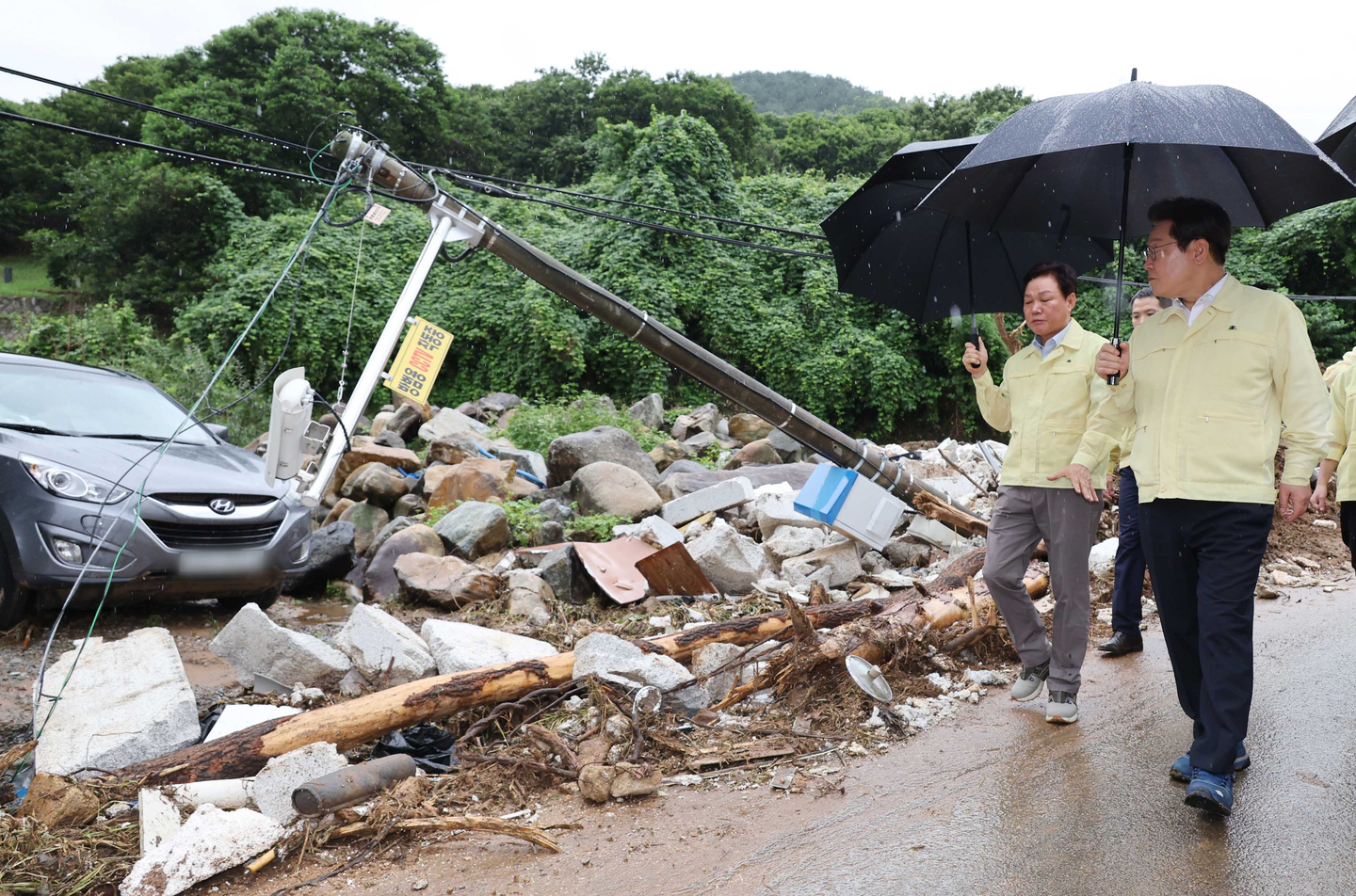 President Lee Jae Myung, far right, visits a town in Sancheong-eup, Sancheong, South Gyeongsang, to inspect damage from an extreme downpour on July 21. [JOINT PRESS CORPS]