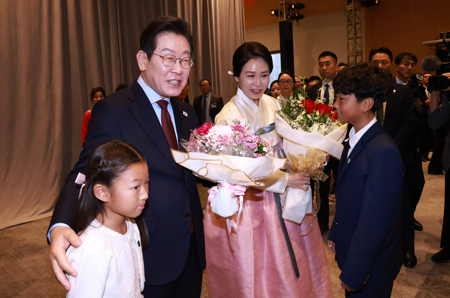 President Lee Jae Myung, left, and first lady Kim Hea Kyung receive flowers during a meeting with members of the Korean diaspora at a hotel in Washington on Aug. 24. [YONHAP]