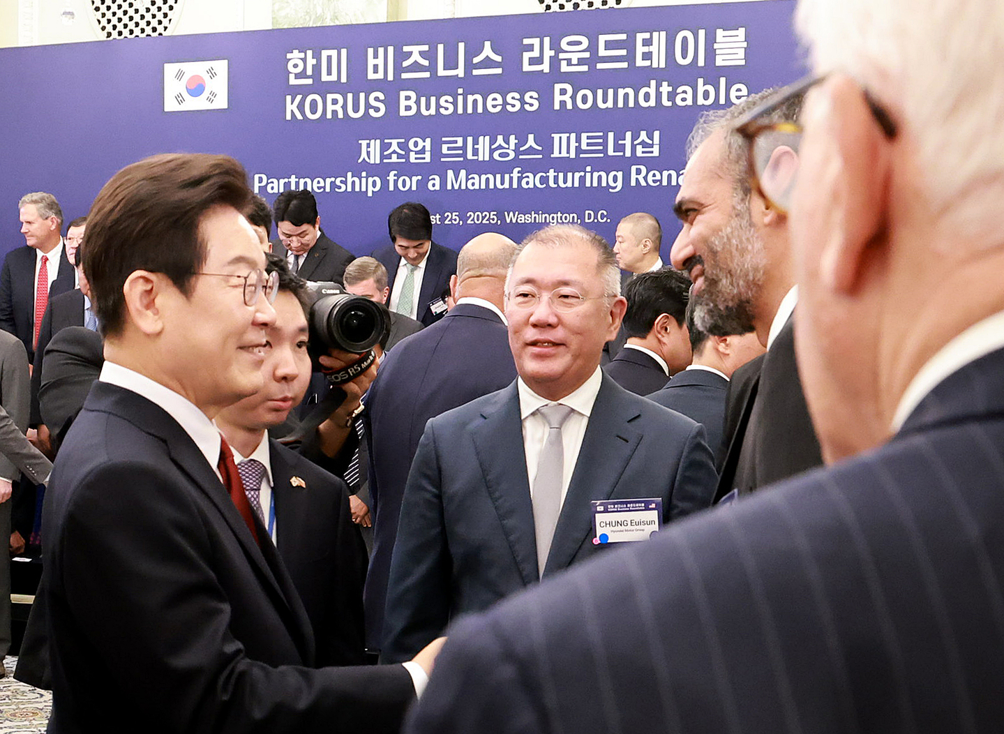 President Lee Jae Myung, left, greets U.S. business leaders at the Korus roundtable reception at the Willard InterContinental Washington in Washington on Aug. 25, introduced by Hyundai Motor Group Executive Chair Euisun Chung. [YONHAP]