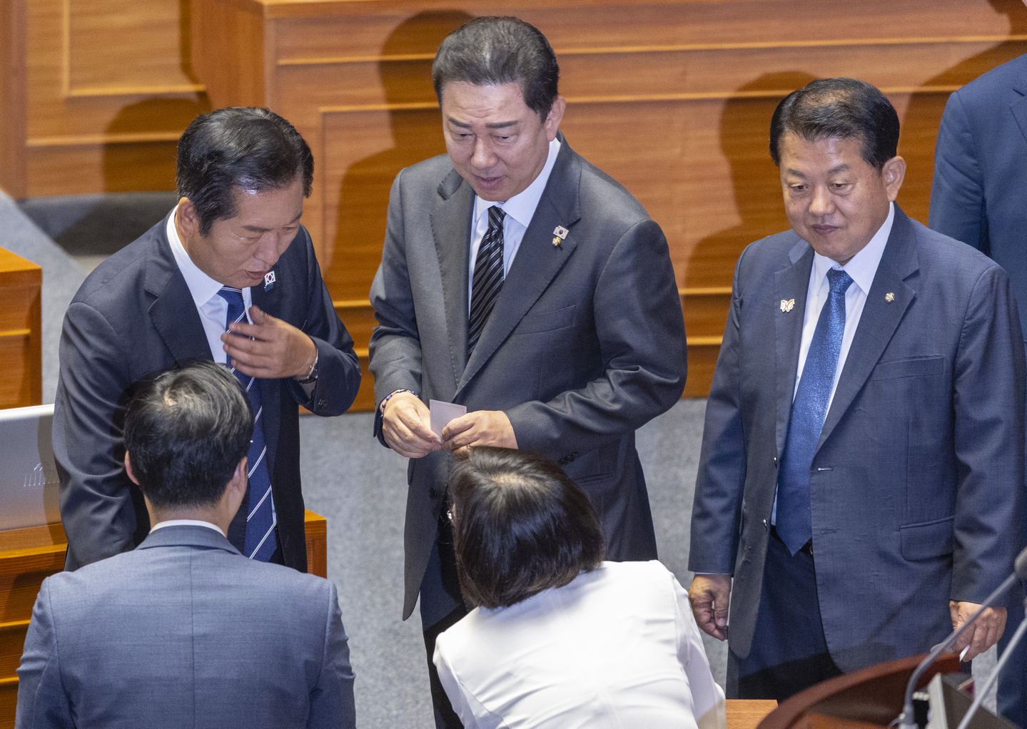 Jeong Cheong-rae, leader of the ruling Democratic Party (left), floor leader Kim Byung-ki and other members of the party’s Supreme Council leave the voting booth after casting ballots to end a filibuster on revisions to the Commercial Act during a plenary session at the National Assembly in Seoul on Aug. 25. The amendment later passed the legislature. [YONHAP]