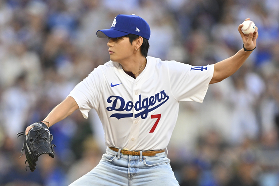 V of boy band BTS throws out a ceremonial first pitch before a baseball game between the Los Angeles Dodgers and the Cincinnati Reds in Los Angeles on Aug. 25. [AP/YONHAP]