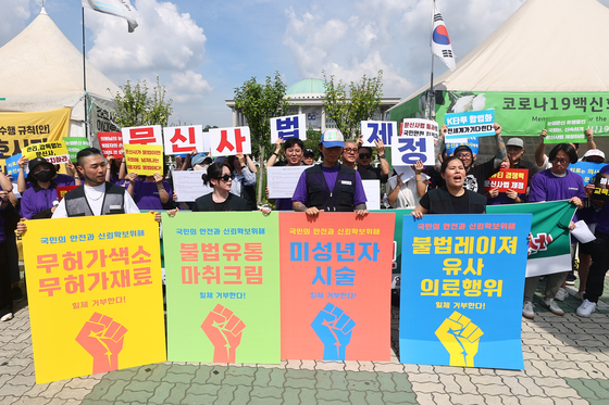 Members of the Korea Tattoo Federation hold a press conference in front of the National Assembly in Yeouido, western Seoul, on Aug. 27, calling for the legalization of tattooing and staging a performance against illegal practices. [YONHAP]
