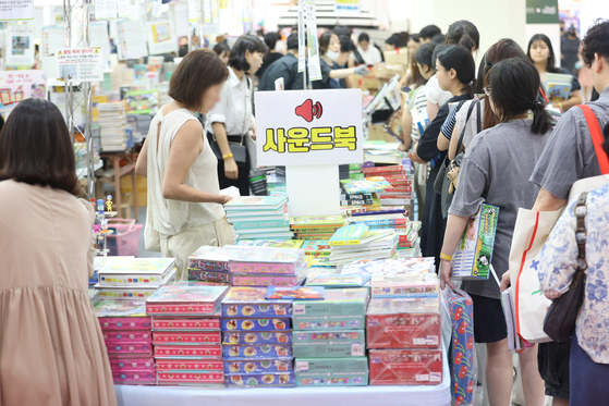 Parents line up to buy learning materials and picture books for children at a kids fair in Coex, Gangnam District, southern Seoul on July 10. [YONHAP] 