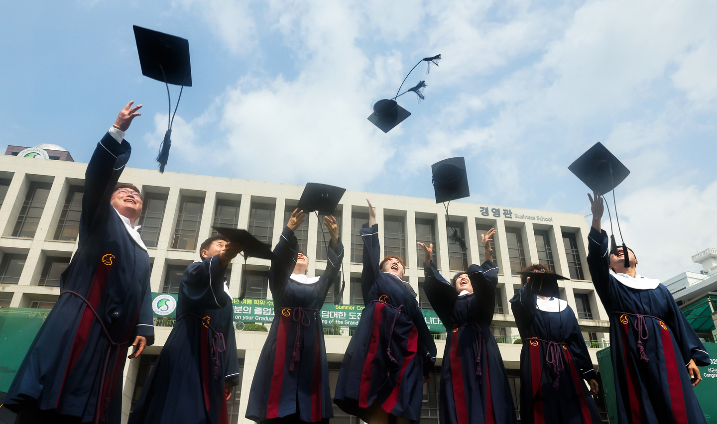 Students throw their graduation caps at the Sungkyunkwan University campus in Jongno District, central Seoul, on Aug. 25, the day of the university's commencement ceremony. [YONHAP]