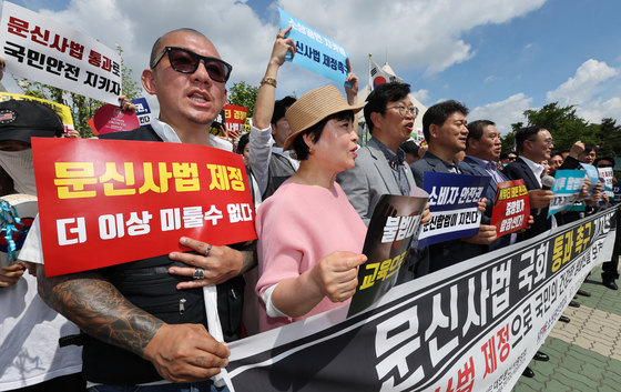 Members of the Korea Tattoo Federation hold a press conference in front of the National Assembly in Yeouido, western Seoul, on Aug. 20. [YONHAP] 