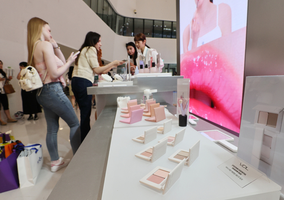 Influencers look at the exhibition booth at the 2025 Seoul Beauty Week, held at the Dongdaemun Design Plaza in central Seoul. [YONHAP] 
