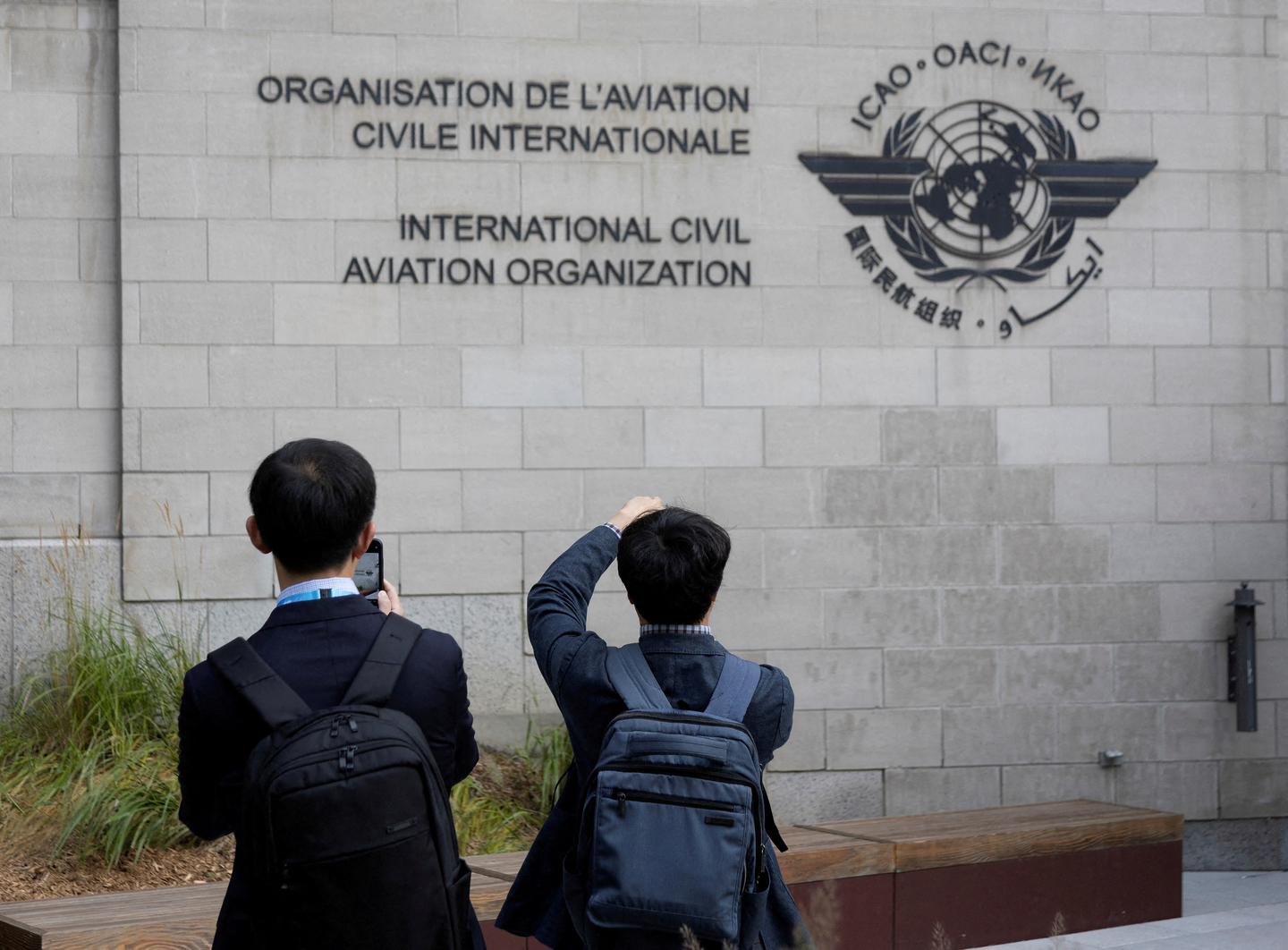 Members of the International Civil Aviation Organization (ICAO) agency take photos of the logo as they arrive at ICAO headquarters in Montreal on Oct. 1, 2022. [REUTERS/YONHAP]