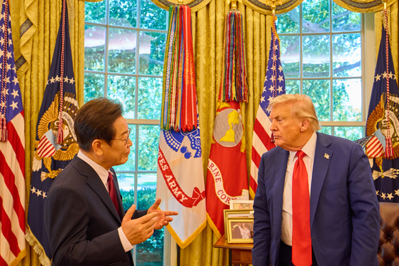Korean President Lee Jae Myung, left, and U.S. President Donald Trump chat in the Oval Office at the White House in Washington on Aug. 25. The two leaders held their first bilateral summit, followed by a working lunch. [JOINT PRESS CORPS]