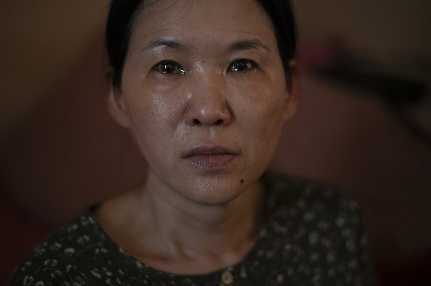 Yooree Kim, who was 11 when she was sent by an adoption agency to a couple in France, sits for a portrait as tears well up in her eyes in her apartment in Seoul on May 19, 2024. [AP/YONHAP]