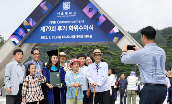 A graduate poses for a commemorative photo with family members at Seoul National University in Gwanak-gu, Seoul, during the 79th late commencement ceremony on Aug. 28. [NEWS1]