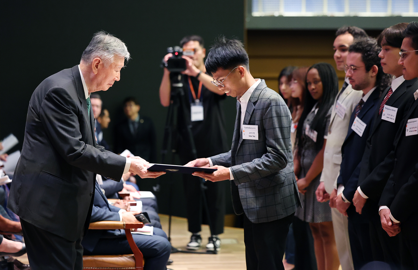 Lee Joong-keun, chair of the WooJung Education & Culture Foundation and Booyoung Group, hands out scholarship certificates to international students getting scholarships from the foundation on Aug. 27. [NEWS1] 