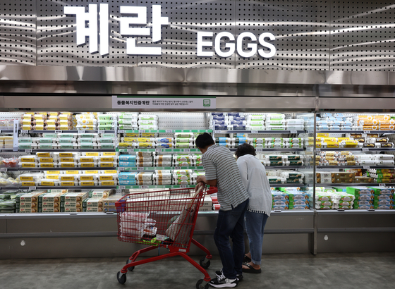 Customers look at eggs stocked at a supermarket in Seoul on June 8. [YONHAP] 