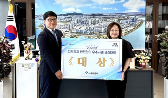 Yongsan District Mayor Park Hee-young, right, and Kim Jin-bae, head of the district's safety and disaster management division, pose for a photo after receiving an award for safety management at a local festival from Seoul Metropolitan Government on Aug. 22. [YONHAP]