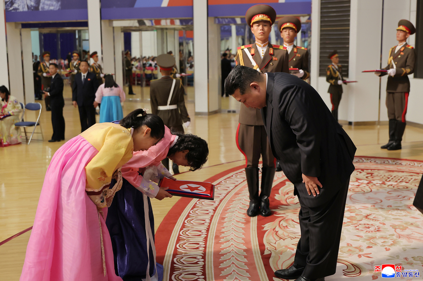 This photo, carried by North Korea's official Korean Central News Agency on Aug. 30, shows the North's leader Kim Jong-un, right, bowing to family members of troops who were deployed to Russia for the war with Ukraine and killed in combat. [YONHAP]