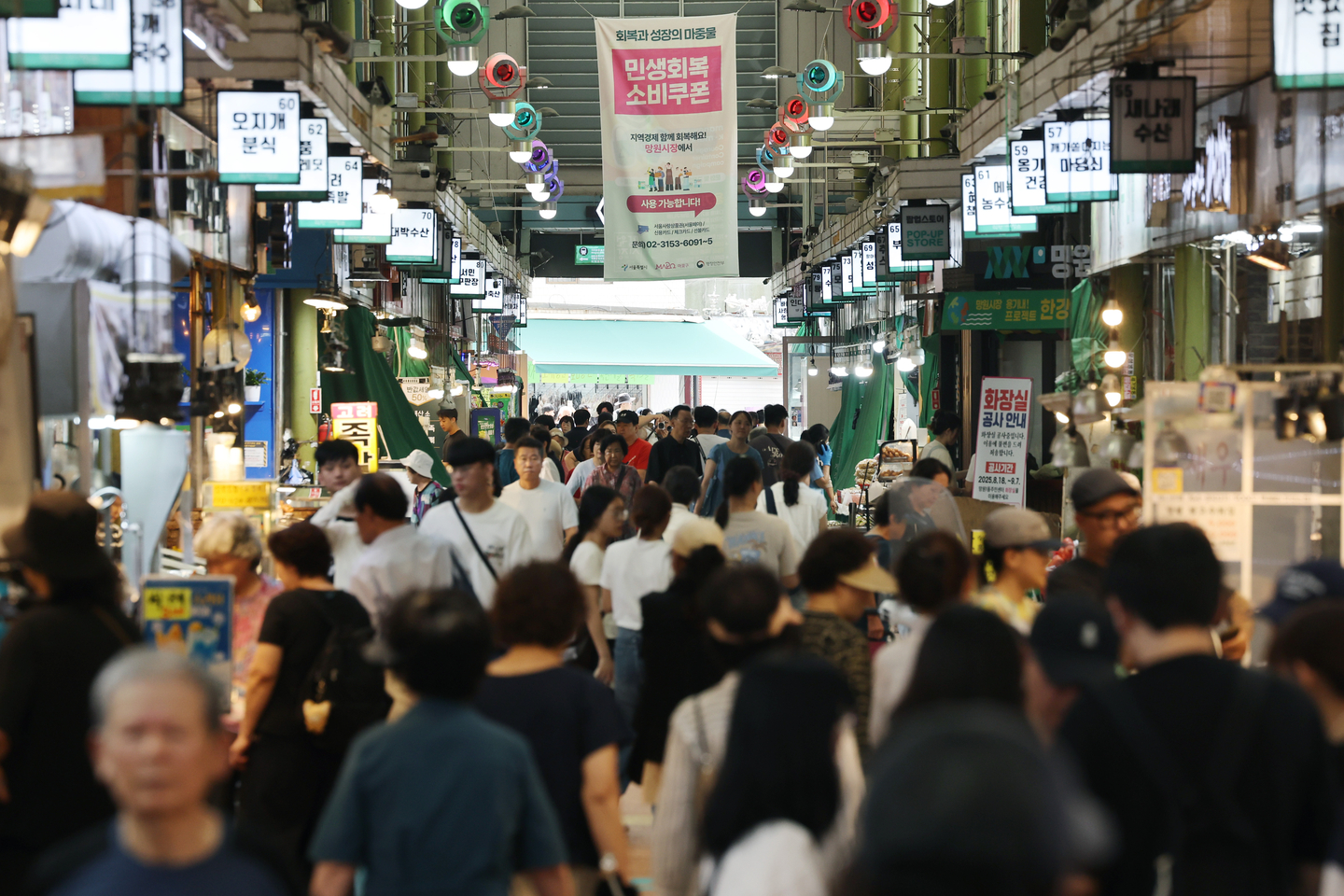 A banner promoting the use of consumer coupons hangs at Mangwon Market in Mapo District, Seoul, on Aug. 26. [YONHAP]