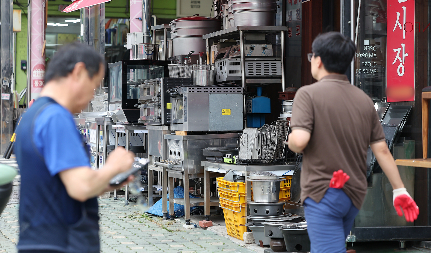 Workers move past stores at a street selling kitchenware in Hwanghak-dong, Jung District, central Seoul, on Aug. 28. [NEWS1]