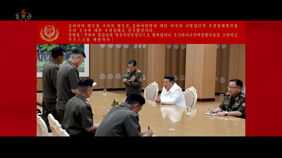 This image captured on Aug. 30 from the music video of the song titled ″Remember,″ aired by the Korean Central Television, shows North Korean leader Kim Jong-un, center, presiding over a meeting with military officials. [YONHAP]