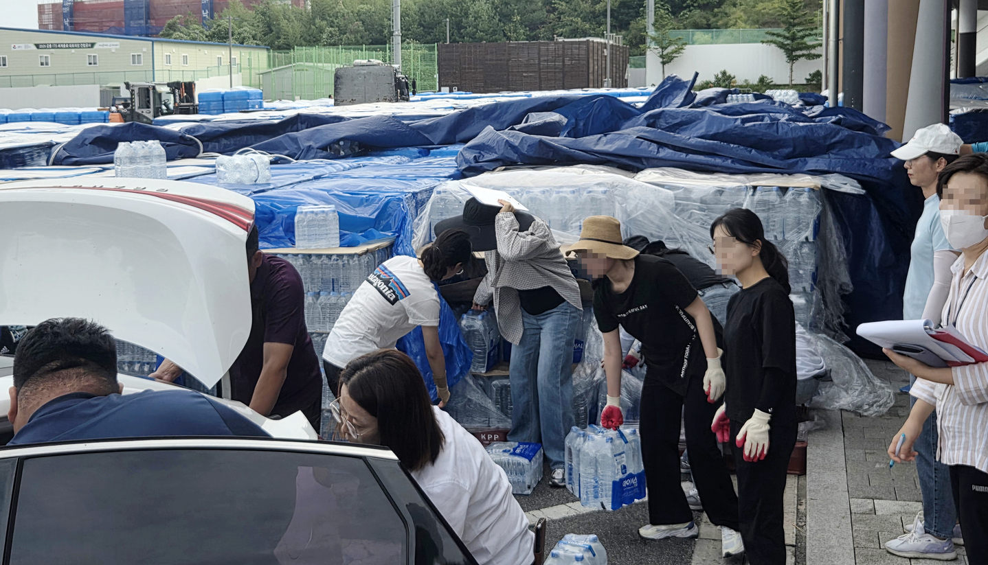 Packs of bottled water that will be delivered to schools, older adult centers and kindergartens in Gangneung, Gangwon, amid the severe drought are unloaded at the city's Gangneung Arena parking lot on Aug. 29. [YONHAP] 