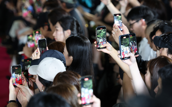 Spectators photograph models walking the stonewall path of Deoksu Palace in central Seoul during Andersson Bell’s show, which opened the 2026 Spring/Summer Seoul Fashion Week on Monday. [NEWS1]