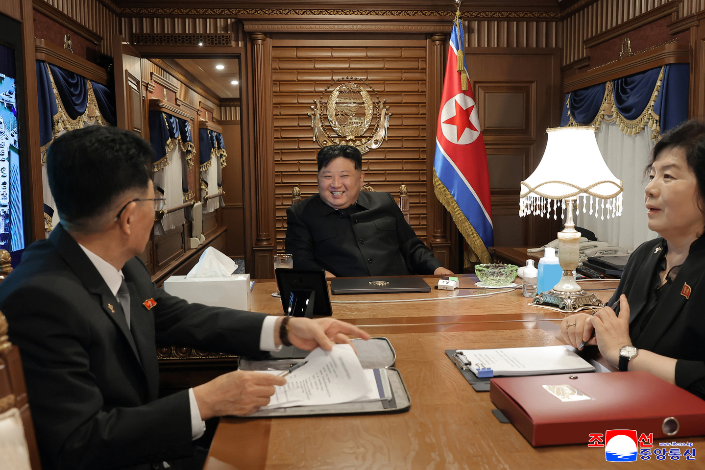 In this photo released by Pyongyang's state-controlled Korean Central News Agency on Sept. 2, North Korean leader Kim Jong-un, center, talks to officials inside his armored train on the way to Beijing to attend a Chinese military parade marking the 80th anniversary of Japan's defeat in World War II. [YONHAP]