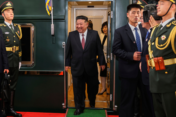 In this photo released by Xinhua News Agency, North Korea leader Kim Jong-un, center, disembarks from a train as he arrives at a railway station in Beijing on Sept. 2. [AP/YONHAP]